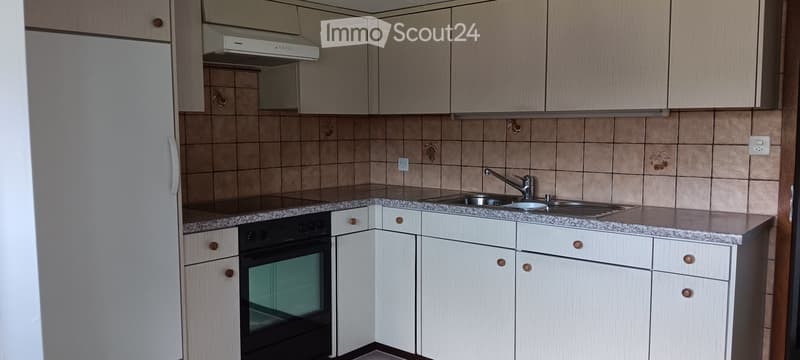White cabinetry, granite countertop, stainless steel sink, black stove, white refrigerator, tiled backsplash