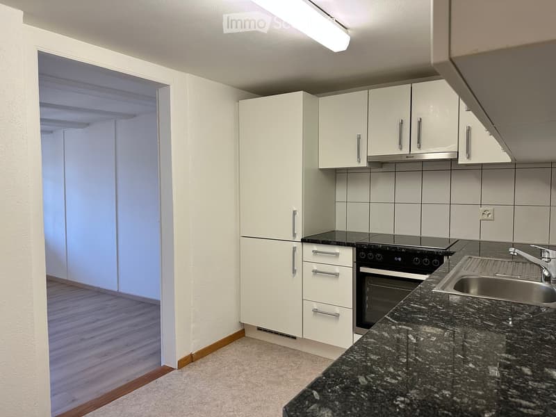 Modern kitchen with white cabinets, granite countertop, stainless steel sink, and built-in oven.
