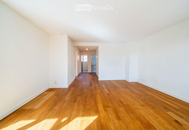 Unfurnished Room. Empty hallway with wooden flooring and white walls, leading to another room.
