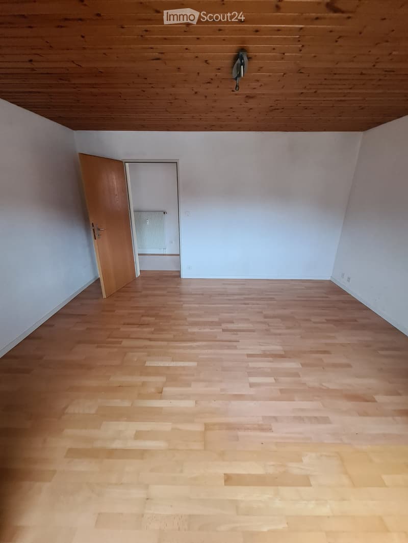 empty room, wooden floor, white walls, wooden ceiling, open door, small window, radiator