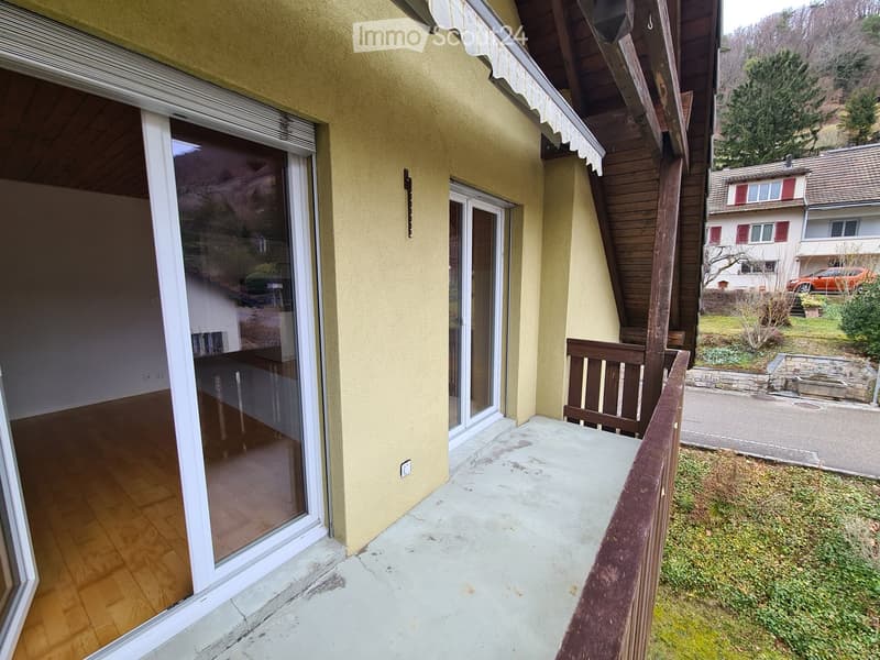 Balcony with wooden railing, glass doors, wooden floor, yellow walls, power outlet