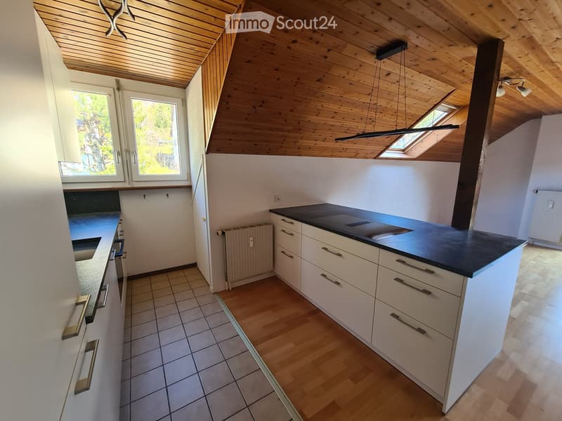 modern kitchen with white cabinets, black countertops, wooden floor, wooden ceiling, windows, radiator, sink, and a hanging lamp