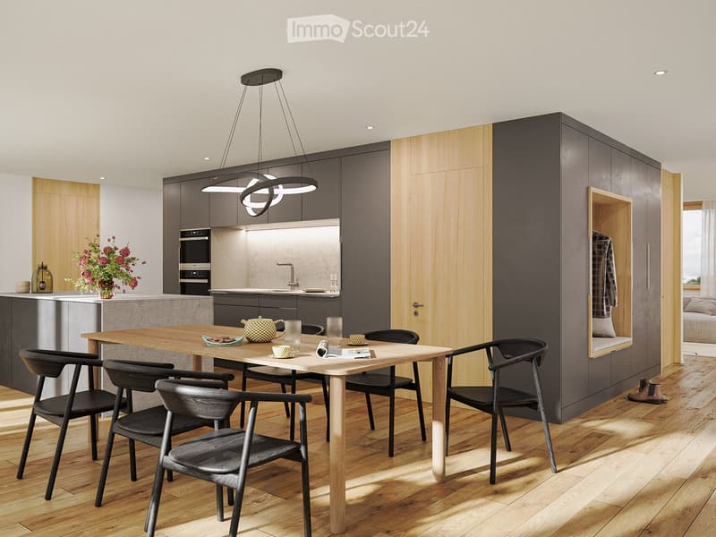 Modern kitchen with a wooden dining table, six chairs, built-in oven, and sleek cabinetry. The space features a hanging light fixture and a vase with flowers on the counter.