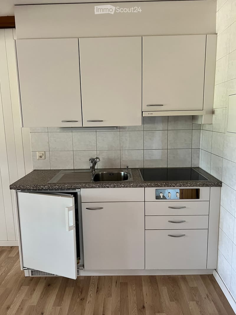 Modern kitchen with white cabinets, granite countertop, stainless steel sink, and built-in appliances.