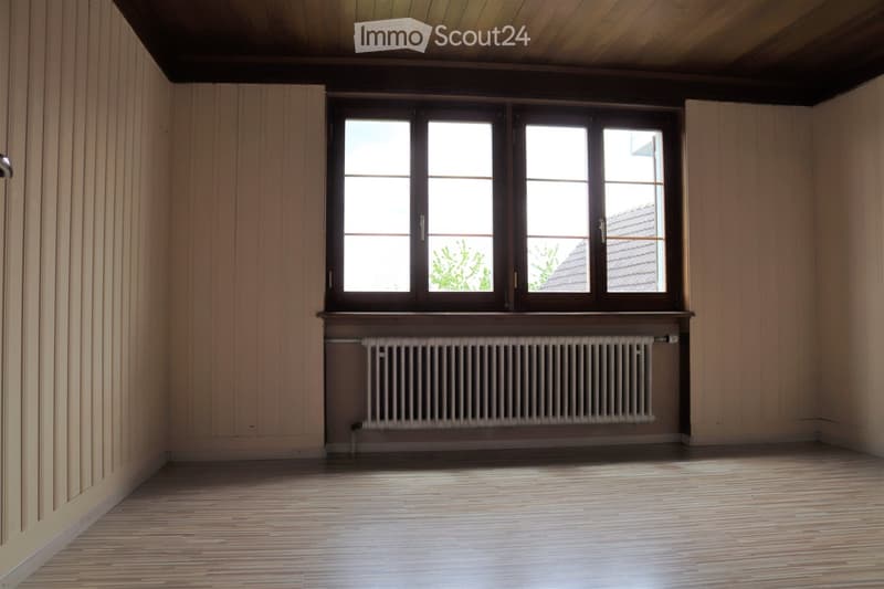 Large window, wood floor, radiator, wooden ceiling