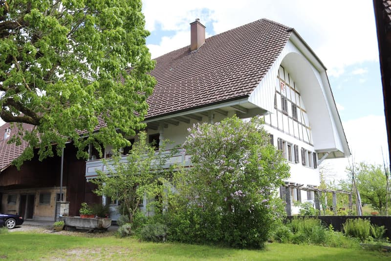 2 story house, brown tiles on roof, brown brick bottom floor, white windows, balcony