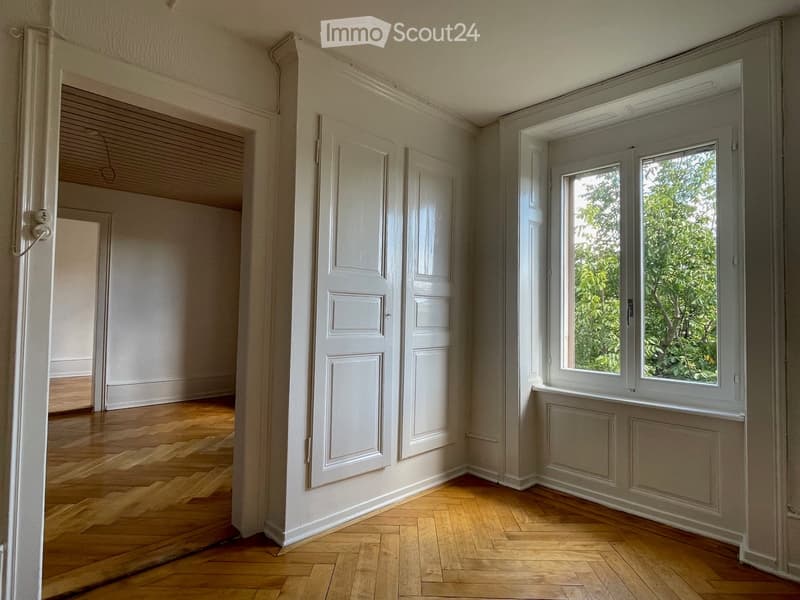 empty room, wooden floor, white walls, large window, view of trees