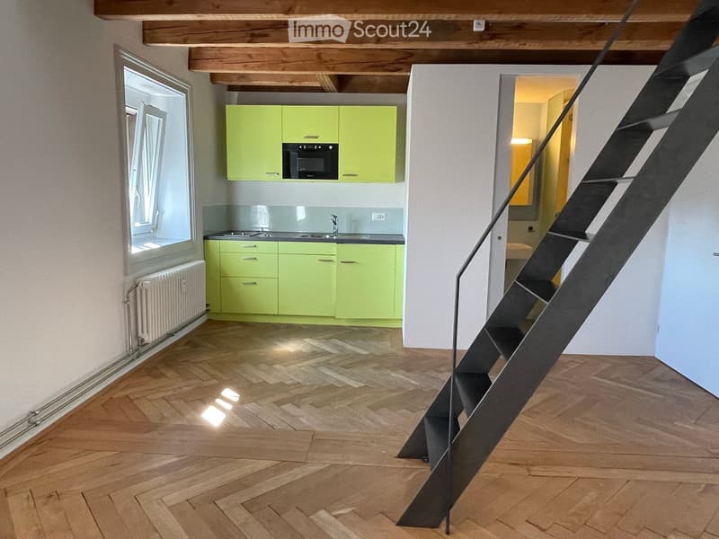 Wooden floor, Yellow kitchen cabinets, White wall, Built-in microwave, Sink, Stove