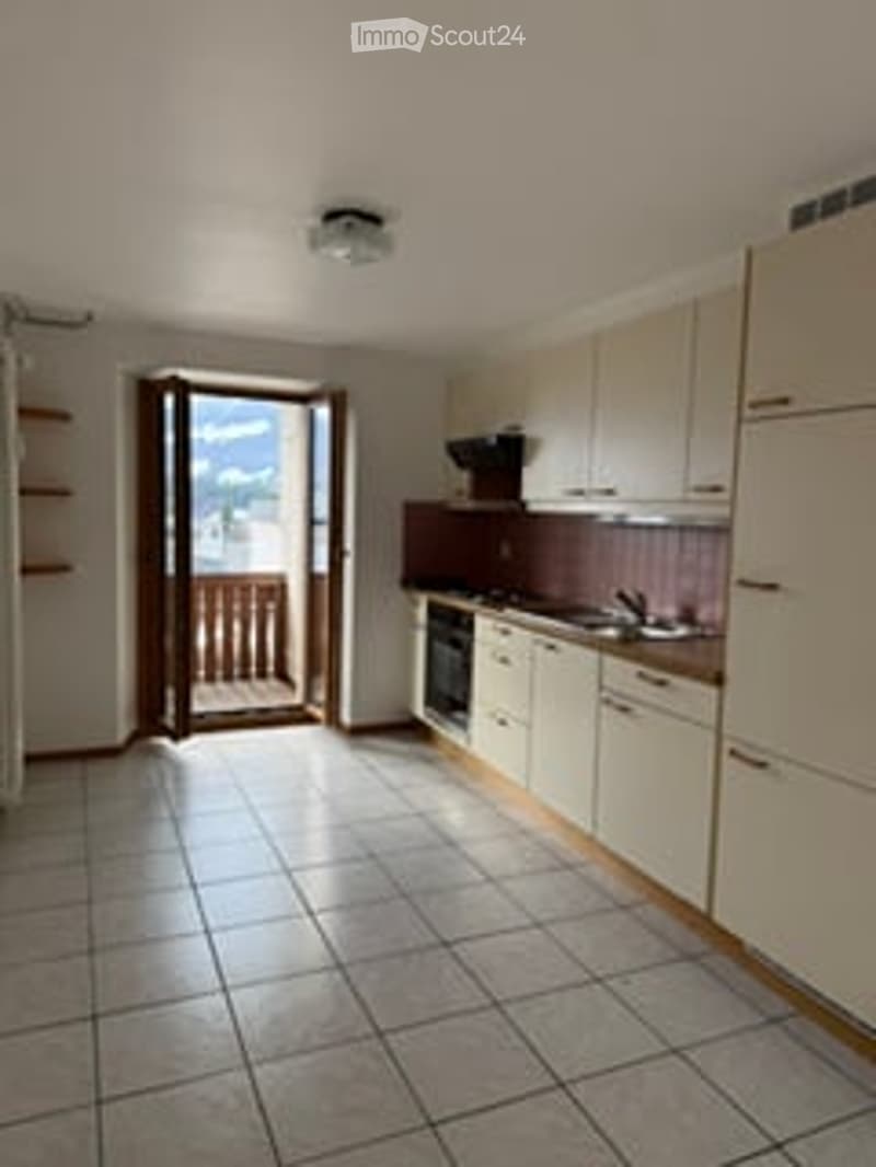 Kitchen. Bright kitchen with white cabinets, tiled floor, and a door leading to a balcony.