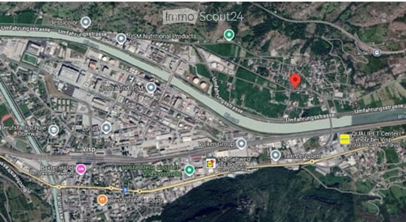 Aerial view of an urban area showing streets, buildings, and a river running through the center. The map includes labeled landmarks and roads.
