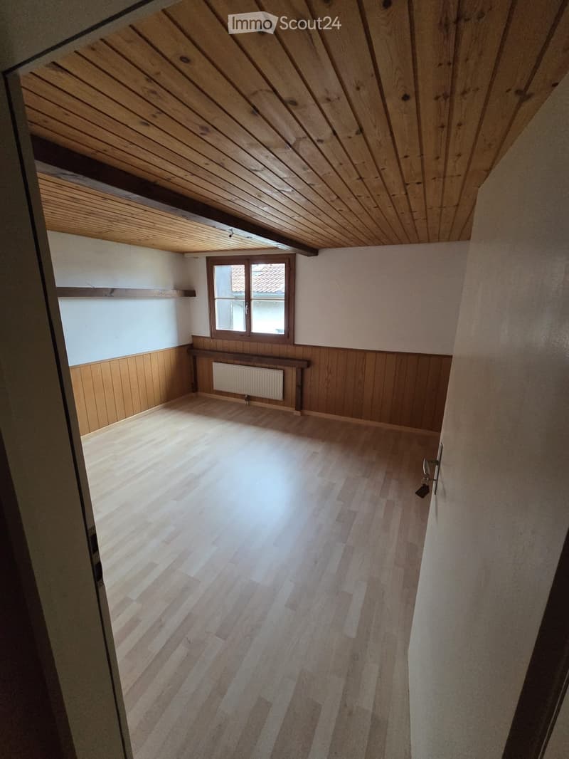 empty room with wooden floor, wooden wall paneling, wooden ceiling, window
