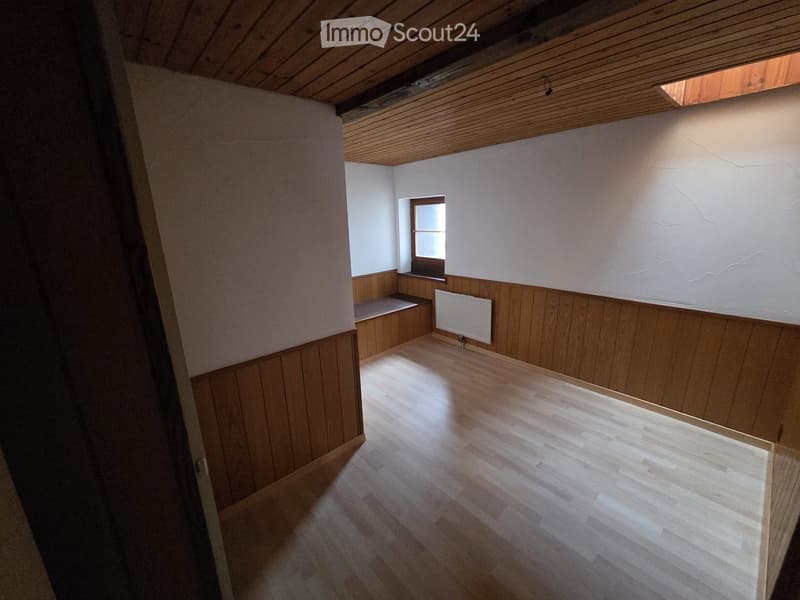 Wooden ceiling, wooden flooring, built-in bench, white walls, radiator, window