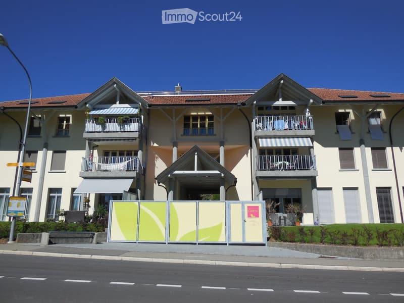 Three-story apartment building, balconies, chimneys, red tiled roof, green signs