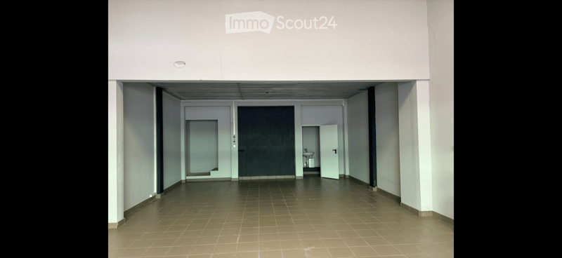 Empty hallway with tiled floor, white walls, and several doors leading to other rooms.