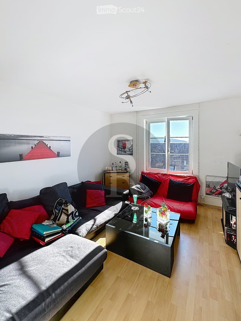 Modern living room with wooden flooring, two sofas, a coffee table, a side table, and a lamp.