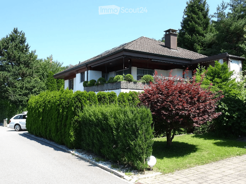 Detached house, white exterior, brown roof, balcony, garden, hedge, driveway, car parked