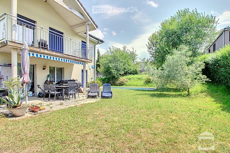 Garden area with a swimming pool, patio furniture, and a covered balcony area with outdoor seating.