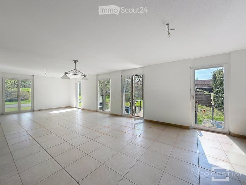 Empty room with white walls, tiled floor, and multiple large glass doors leading to an outdoor area.