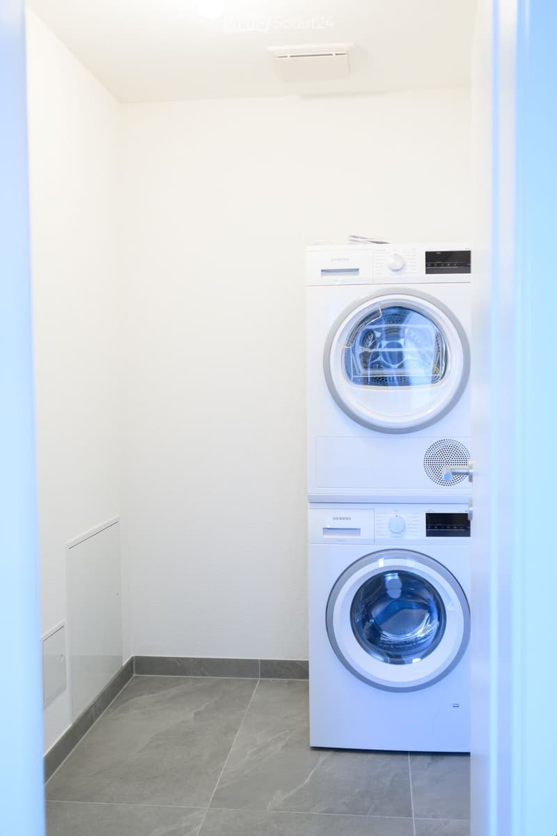 {"visible_features": ["Private washing machine", "Dishwasher"],"type": "Laundry room","description": "White washing machine and dryer stacked, tiled floor, white walls"}