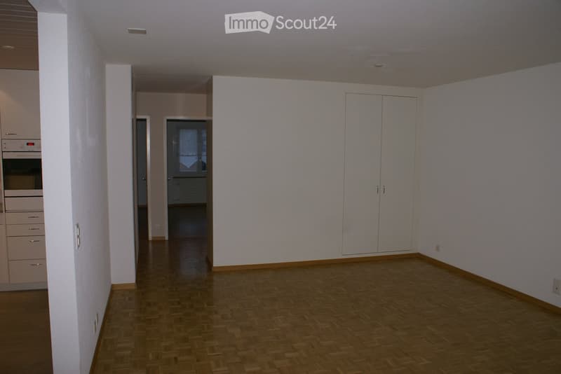 Empty room with white walls, wooden floor, and built-in cabinets. No furniture or equipment.