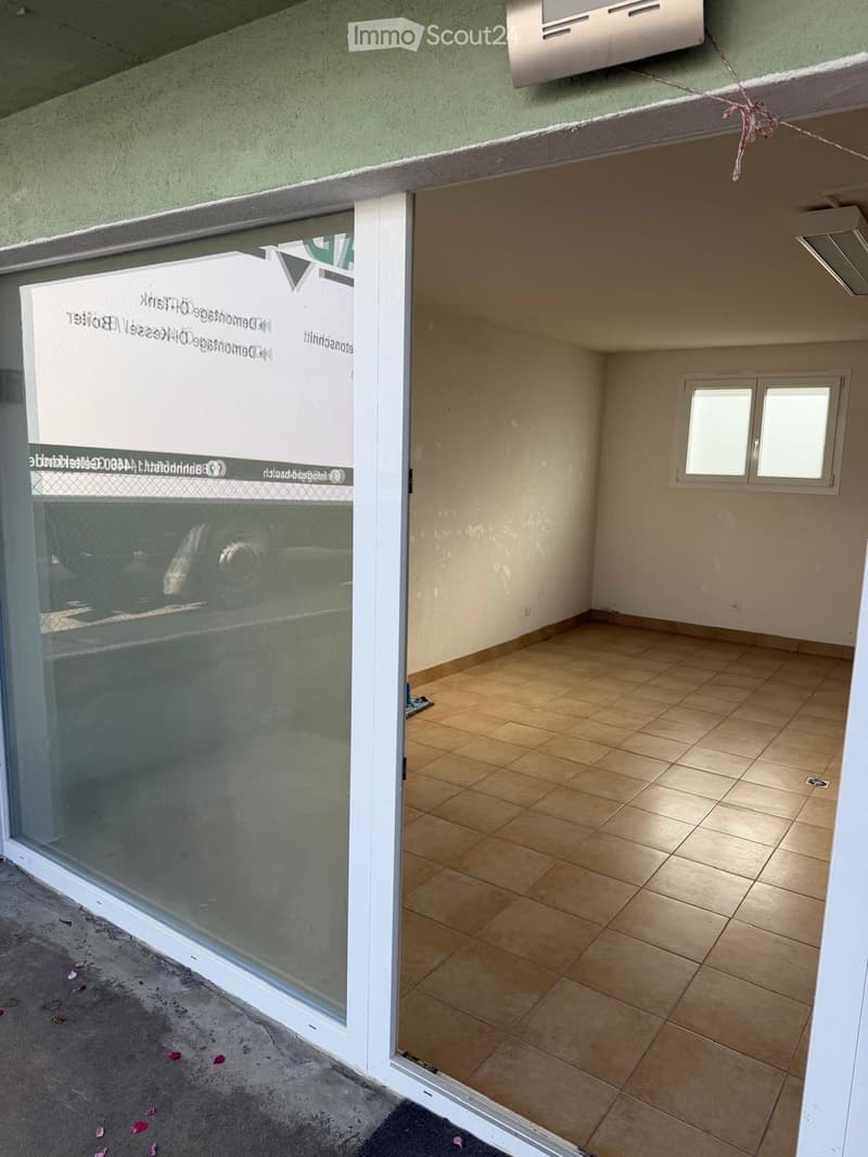 Empty room with tiled floor, white walls, and a small window. The room is unfurnished and has a sliding glass door leading to an outdoor area.