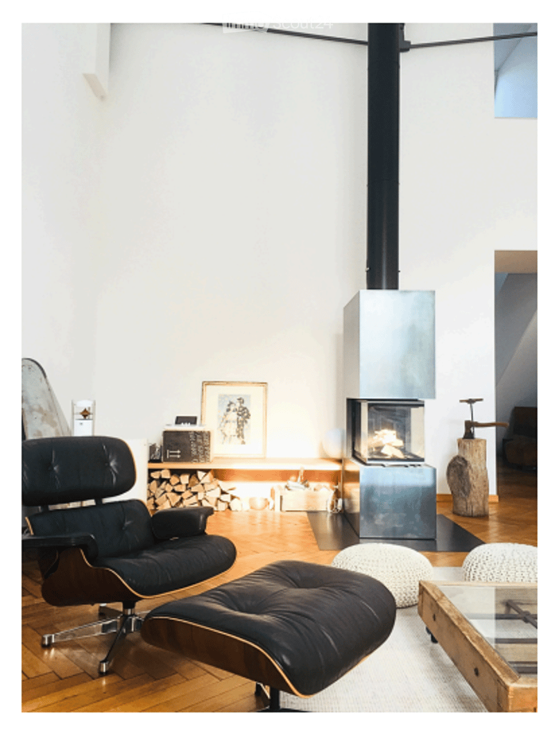 Modern living room with a fireplace, a black leather sofa, a glass coffee table, and a wooden floor.