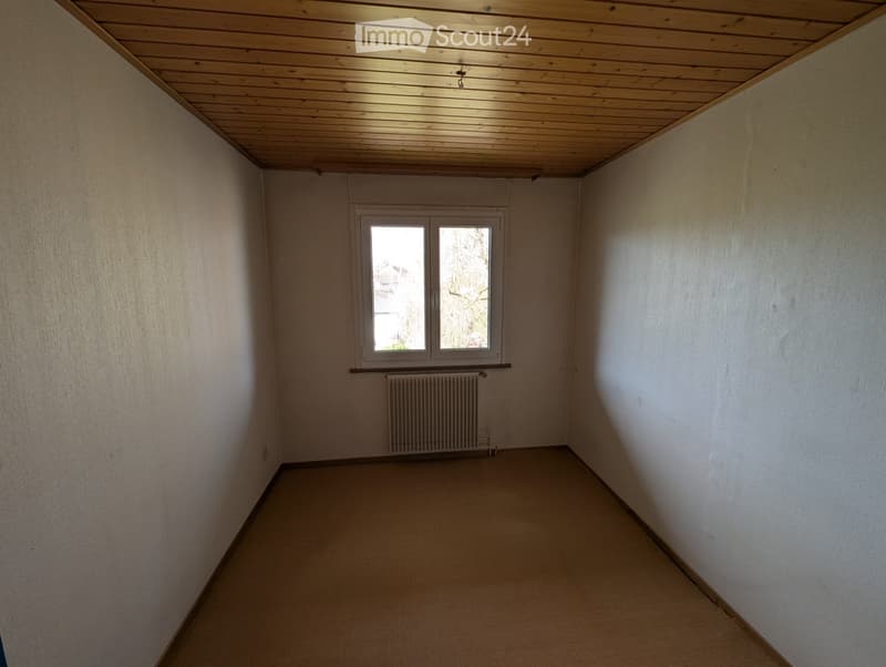 empty room, white walls, wooden ceiling, white radiator, window with view