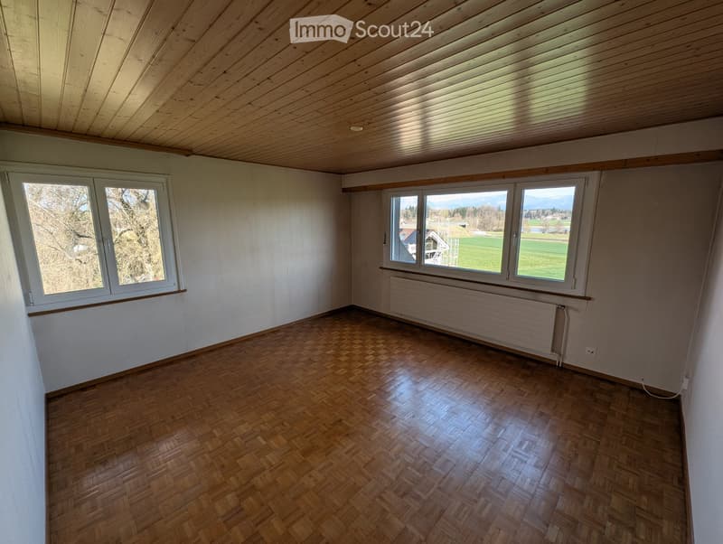 empty room, wooden parquet floor, white walls, wooden ceiling, two windows, radiator