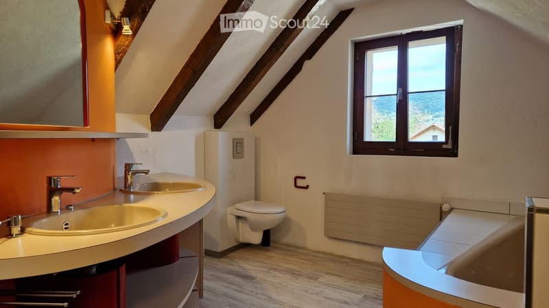 Modern bathroom with double sink, toilet, mirror, and window overlooking a scenic view.
