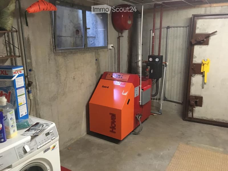Utility room with a washing machine, water heater, and various storage items.