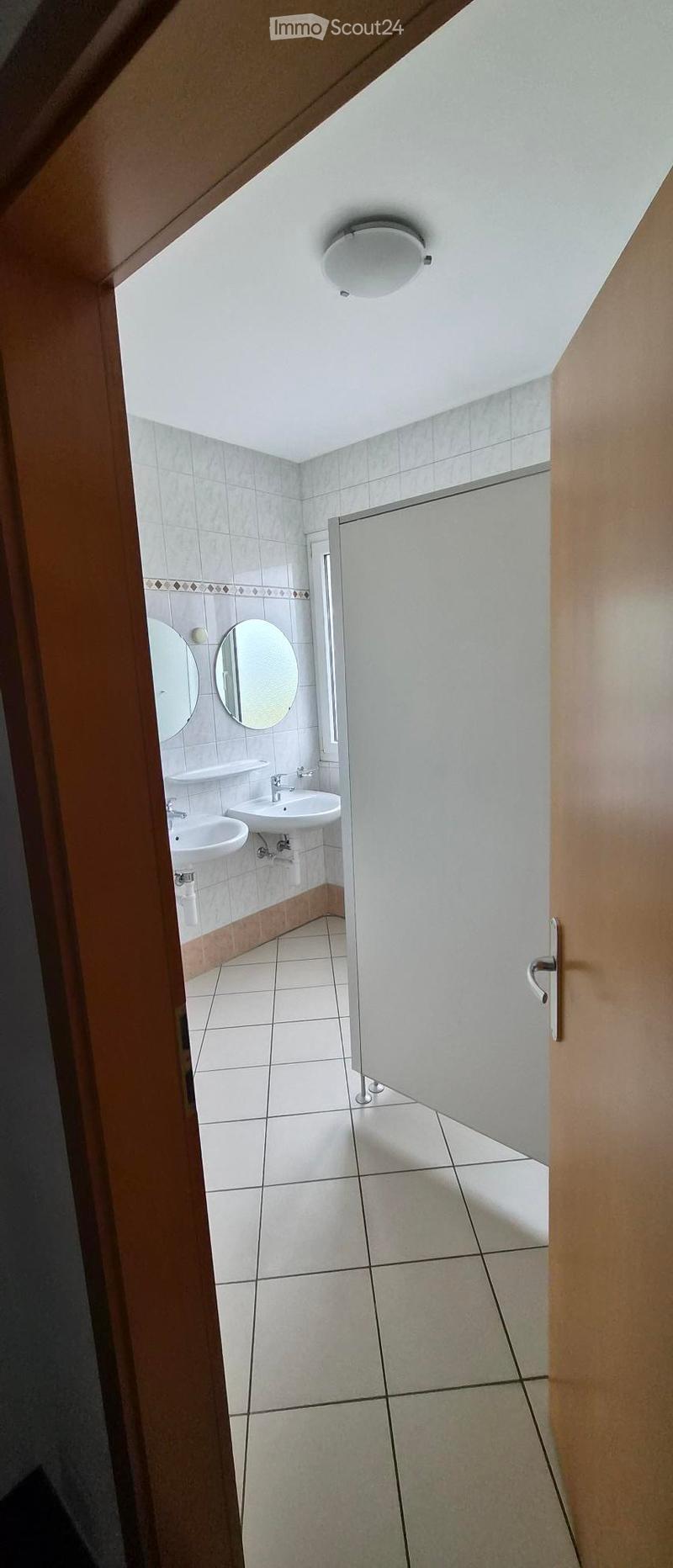 Clean bathroom with two sinks, mirrors, and tiled walls and floor.