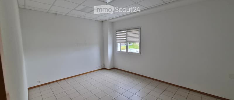 Empty room with white walls, tiled floor, and a single window with blinds.