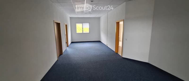 Empty room with bare walls, carpeted floor, and a single window with blinds. No furniture or equipment present.