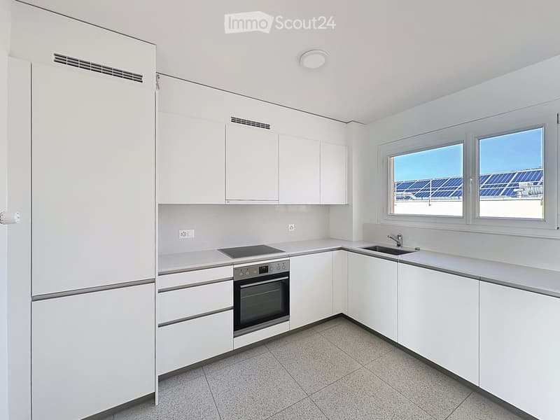Modern, minimalist kitchen with white cabinets, stainless steel appliances, and a sleek design. Features a sink, faucet, and oven.