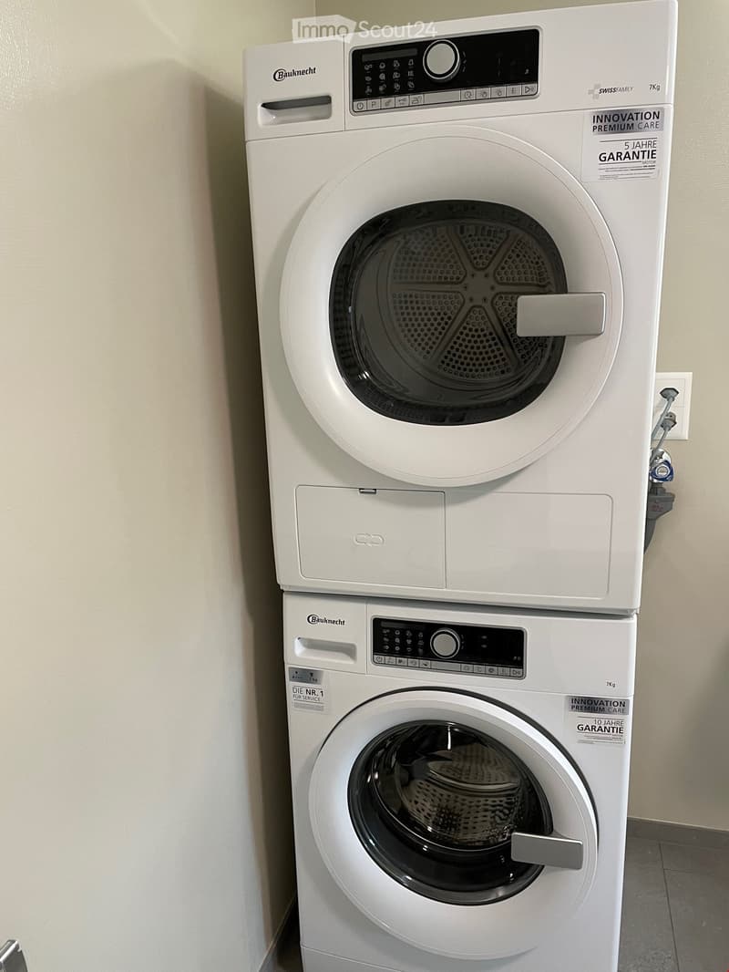 A white washing machine and dryer stacked vertically, with control panels and a modern design.