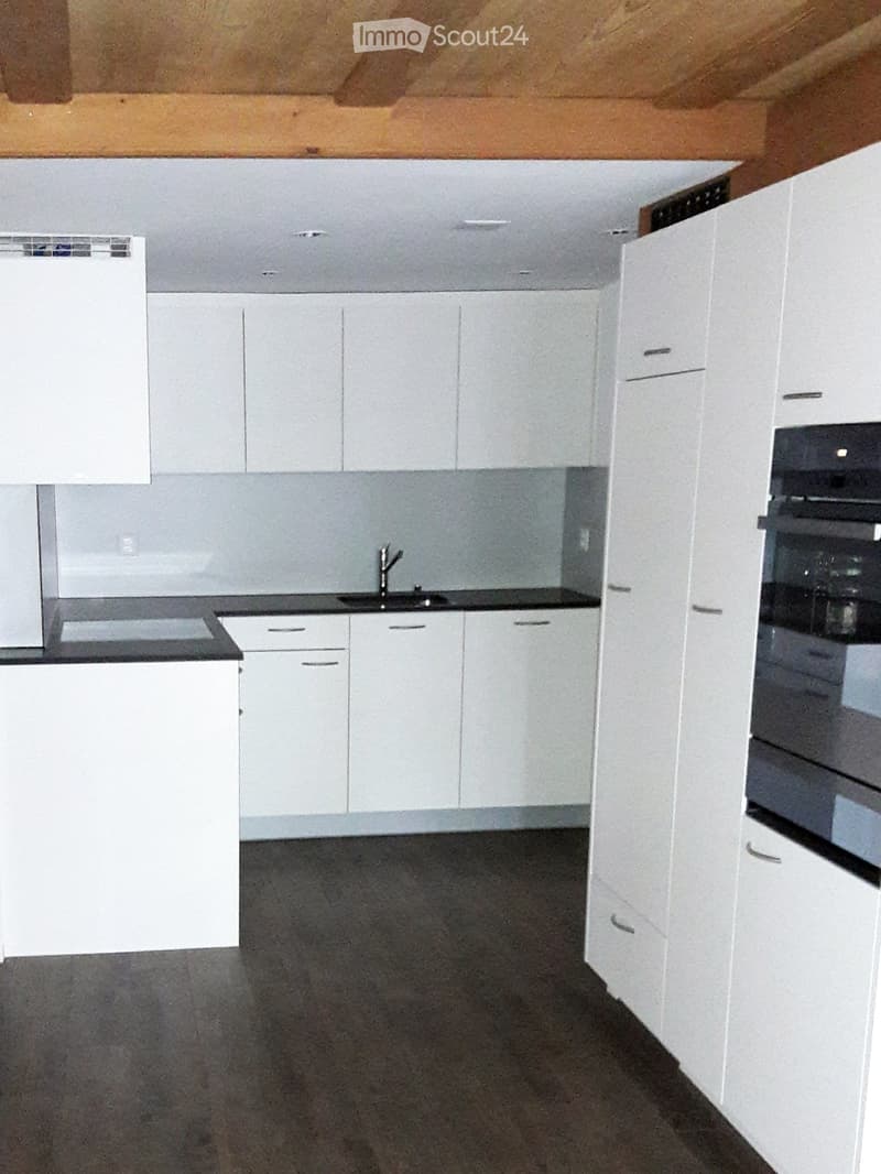 Unfurnished Room. Empty kitchen with white cabinets, dark countertops, and a sink, featuring a modern design with no appliances or furniture.