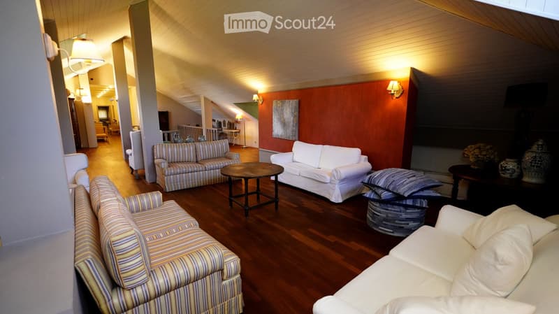 Living room with hardwood floors, multiple sofas, coffee tables, and decorative vases.
