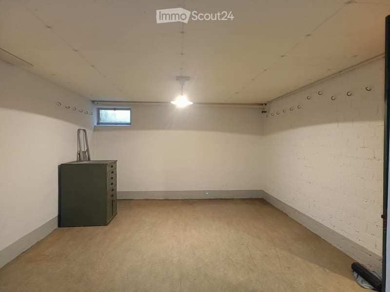 Empty room with bare walls, concrete floor, and a single cabinet. No furniture or equipment visible.