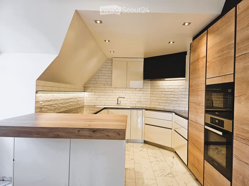 Modern kitchen with white and wood cabinets, a central island, and a built-in oven. The space features a sleek design with a marble floor and recessed lighting.