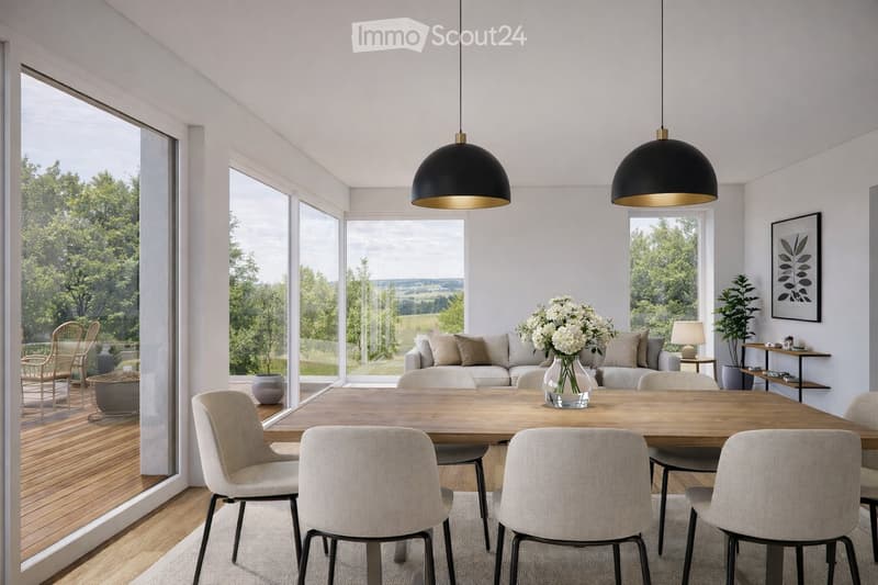 Bright, modern living and dining area with large windows overlooking a green landscape. Features a grey sofa, wooden dining table with six chairs, a vase with white flowers, a table lamp, and a potted plant on a side table.