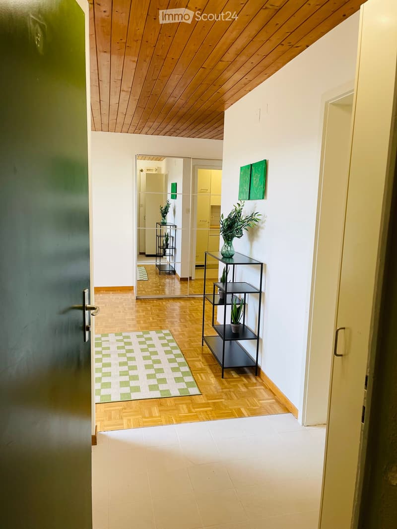 wooden flooring, wooden ceiling, green checked rug, white tiled floor, open door