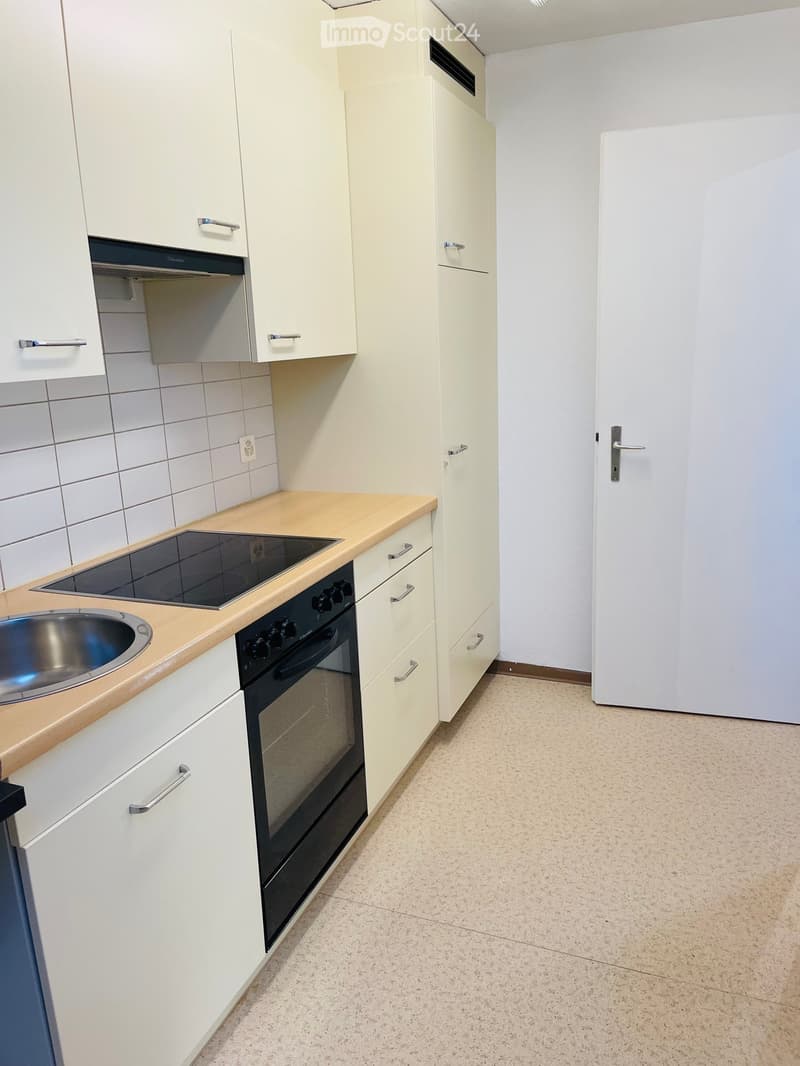 kitchen with black stove, oven, under cabinet drawers, granite counter tops, stainless steel sink