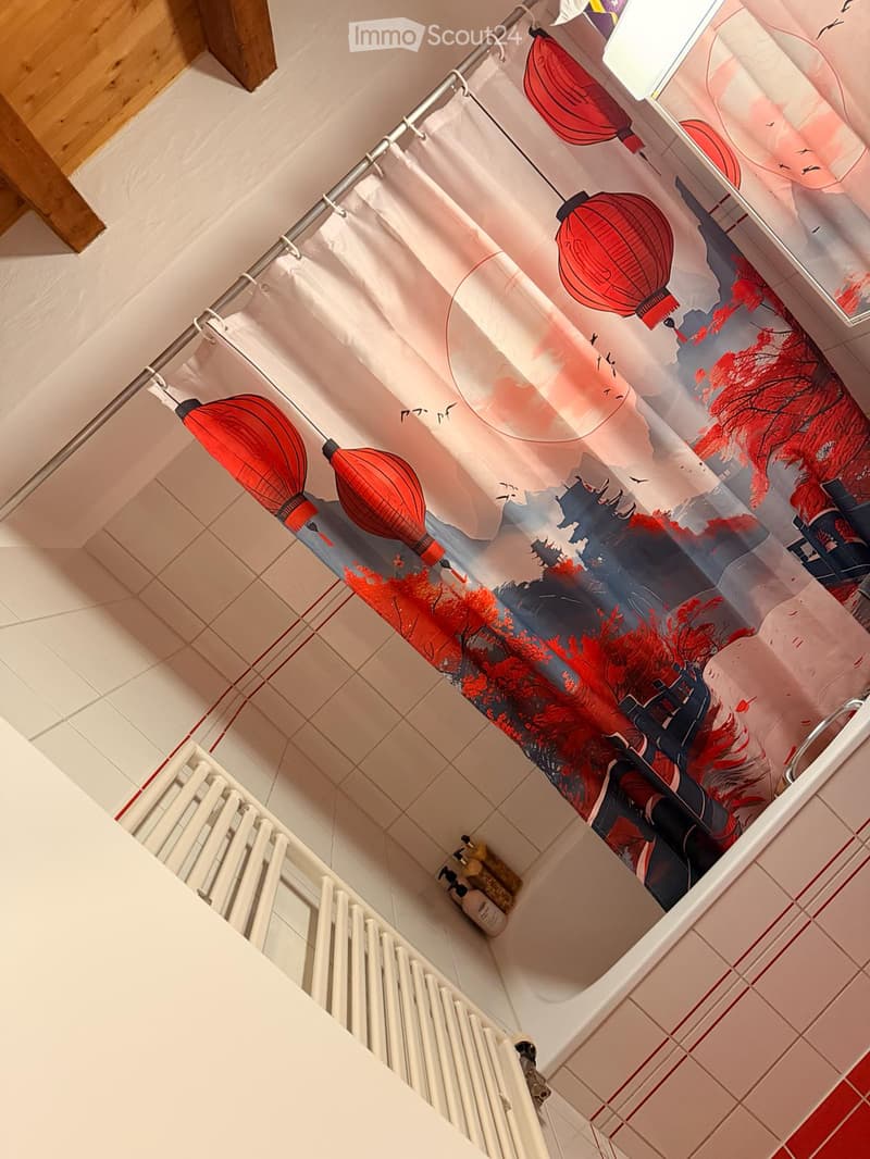 Bathroom with a decorative shower curtain featuring red lanterns and a scenic design, a white radiator, and a bottle on the floor.