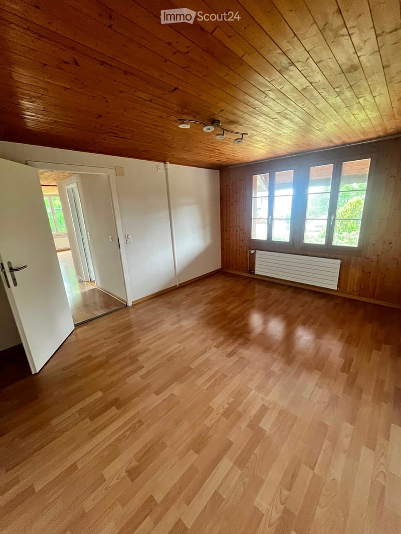 Empty room with wooden flooring, wooden ceiling, large windows, and white walls. No furniture or equipment present.