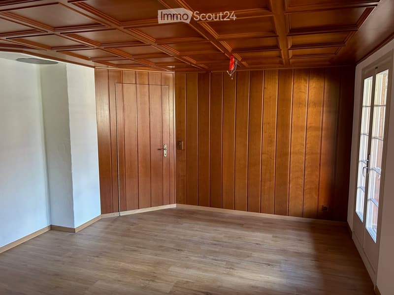 Empty room with wooden panel walls, wooden ceiling, and wooden floor. No furniture or equipment present.