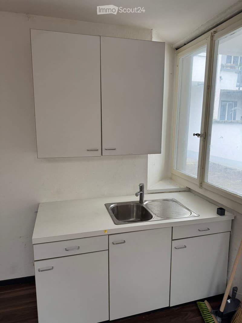 empty kitchen, white cabinets, silver sink, stainless steel faucet, white countertops, window, view outside