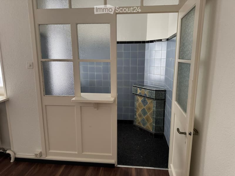 tiled wall, wooden floor, open door, light switch, tiled sink