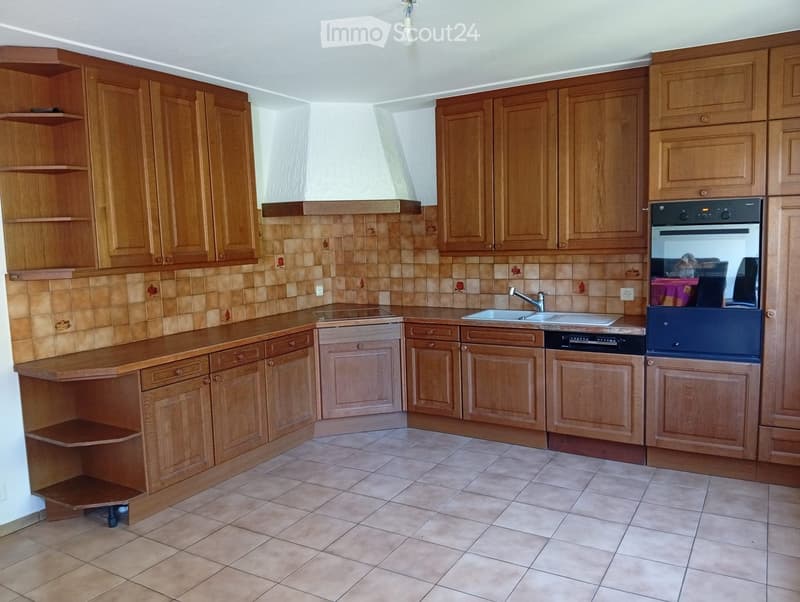 Kitchen with wooden cabinets, tiled backsplash, and tiled floor. Features a sink, faucet, oven, and dishwasher.