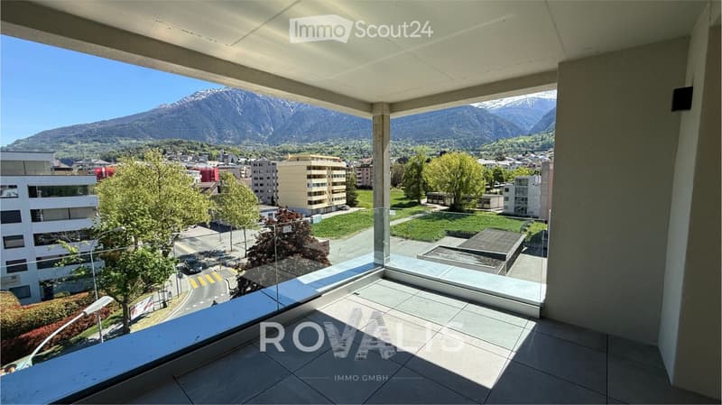 Balcony with modern design, expansive view of cityscape and mountains, tiled floor, glass railing.