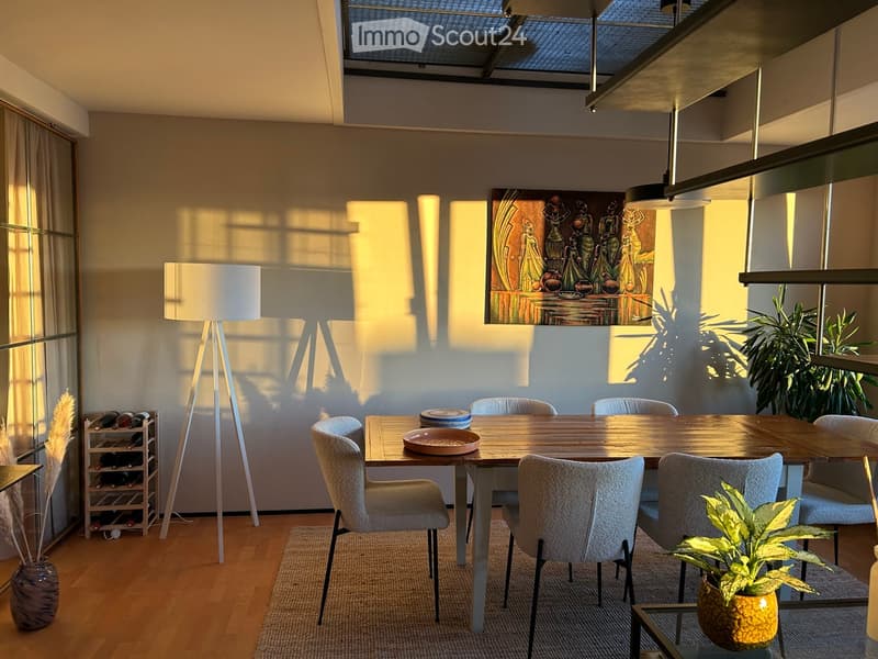 Modern dining area with a wooden table, six chairs, a wine rack, a floor lamp, and a decorative painting on the wall.